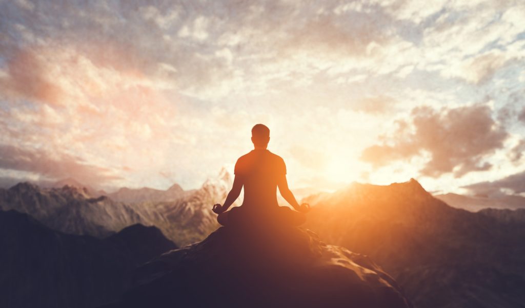 Man in yoga pose, zen meditation at sunset.